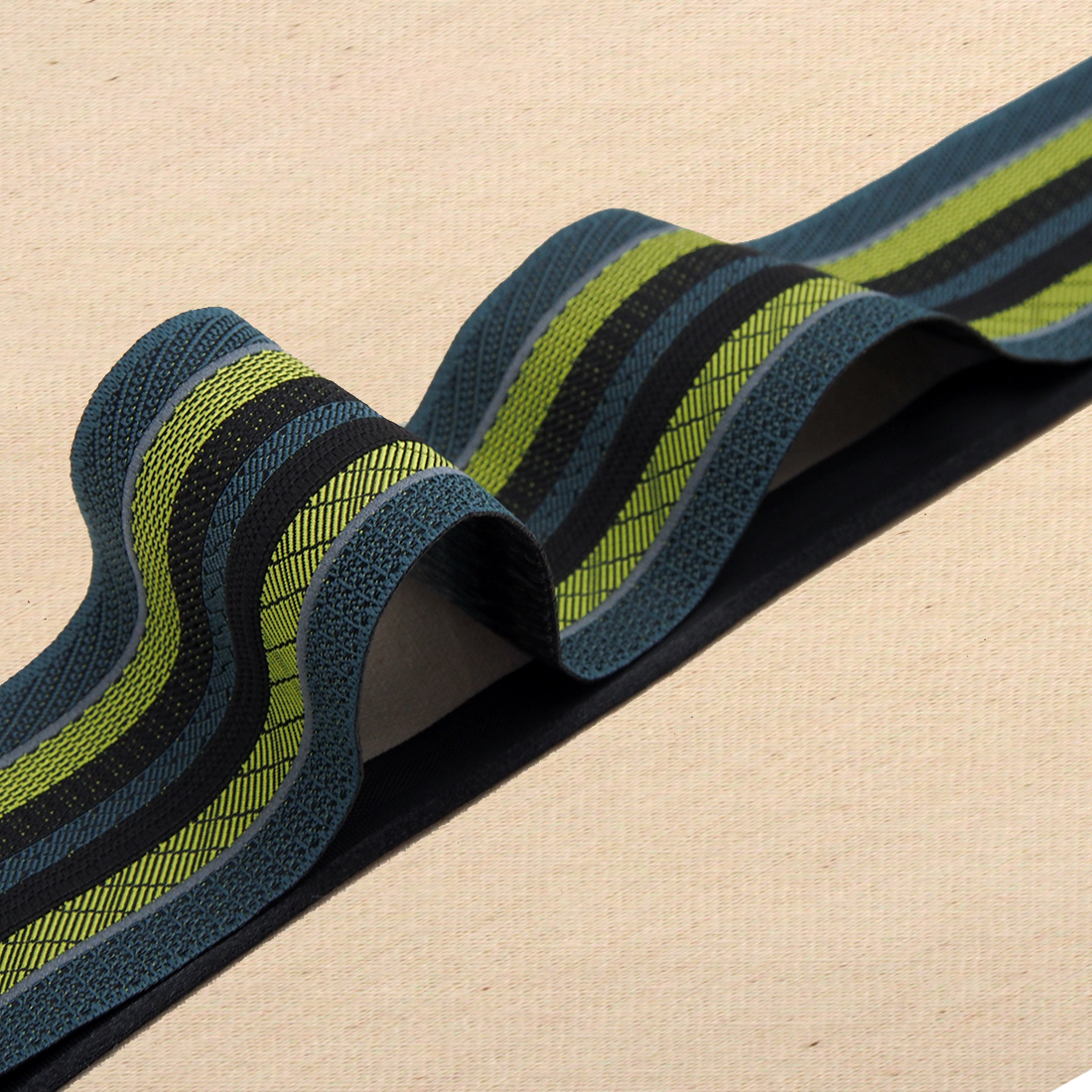 Man sieht ein gestreiftes Band mit neun Bahnen. Die Farben sind petrol, grün/gelb, schwarz und silber reflektieren.